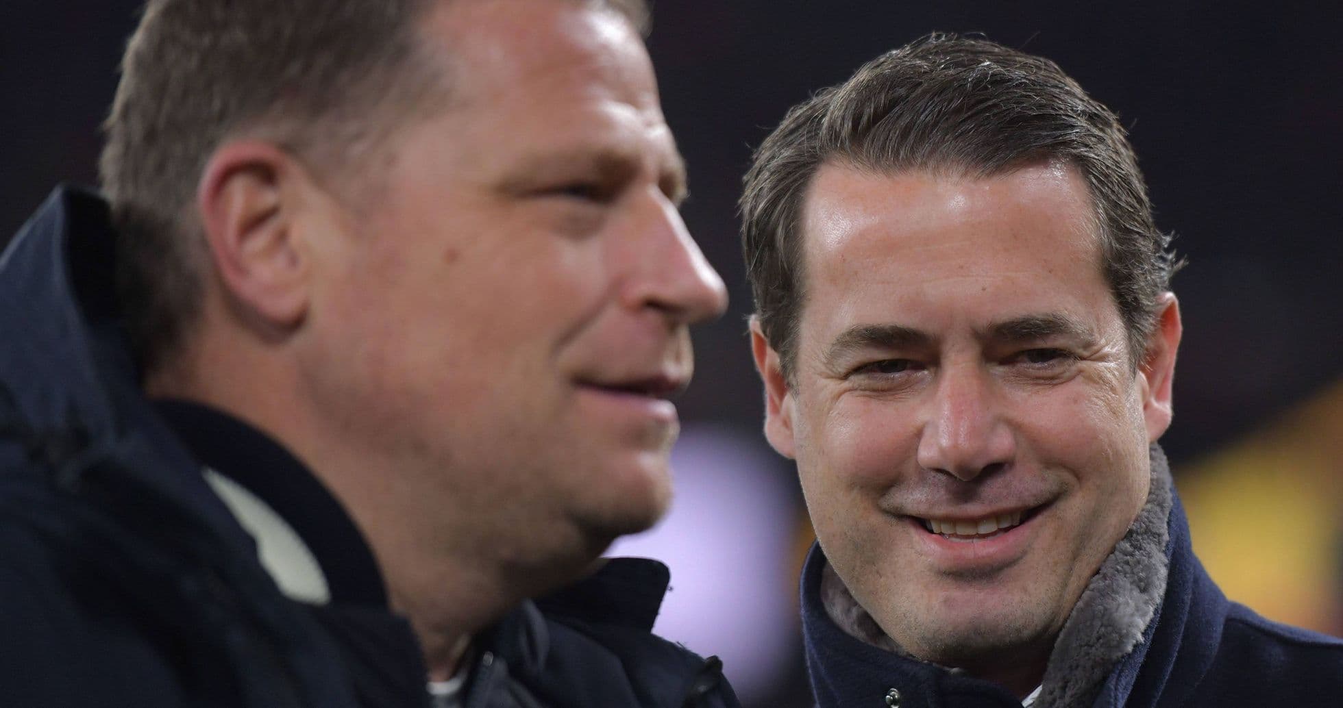 Two men smiling and talking on the sidelines Two men smiling and talking on the sidelines