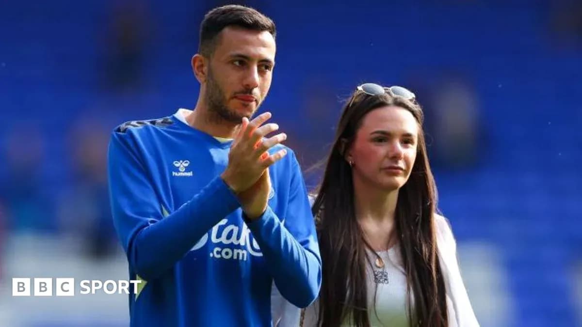 Football player and companion applauding on field Football player and companion applauding on field