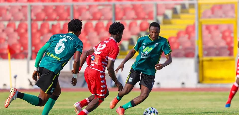 Players competing for the ball during a football match Players competing for the ball during a football match