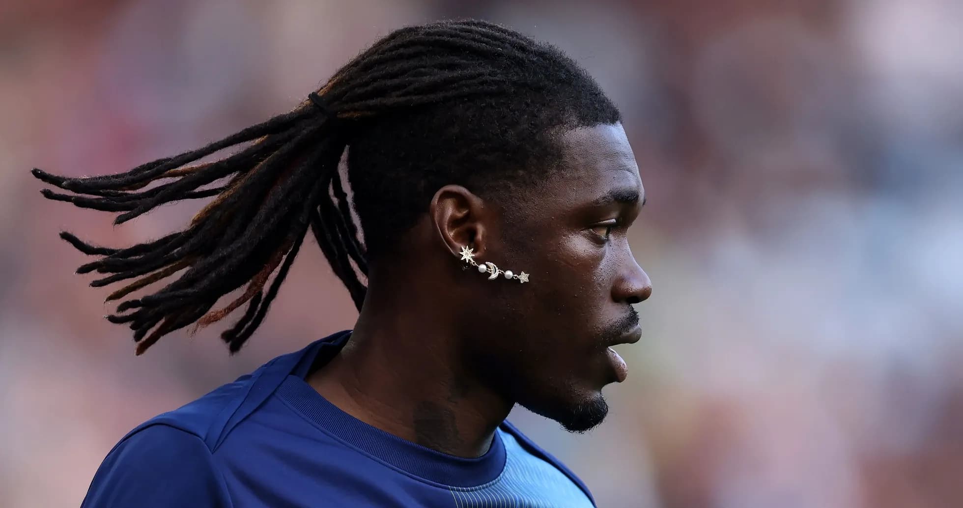 Player with long hair and unique earrings during match Player with long hair and unique earrings during match
