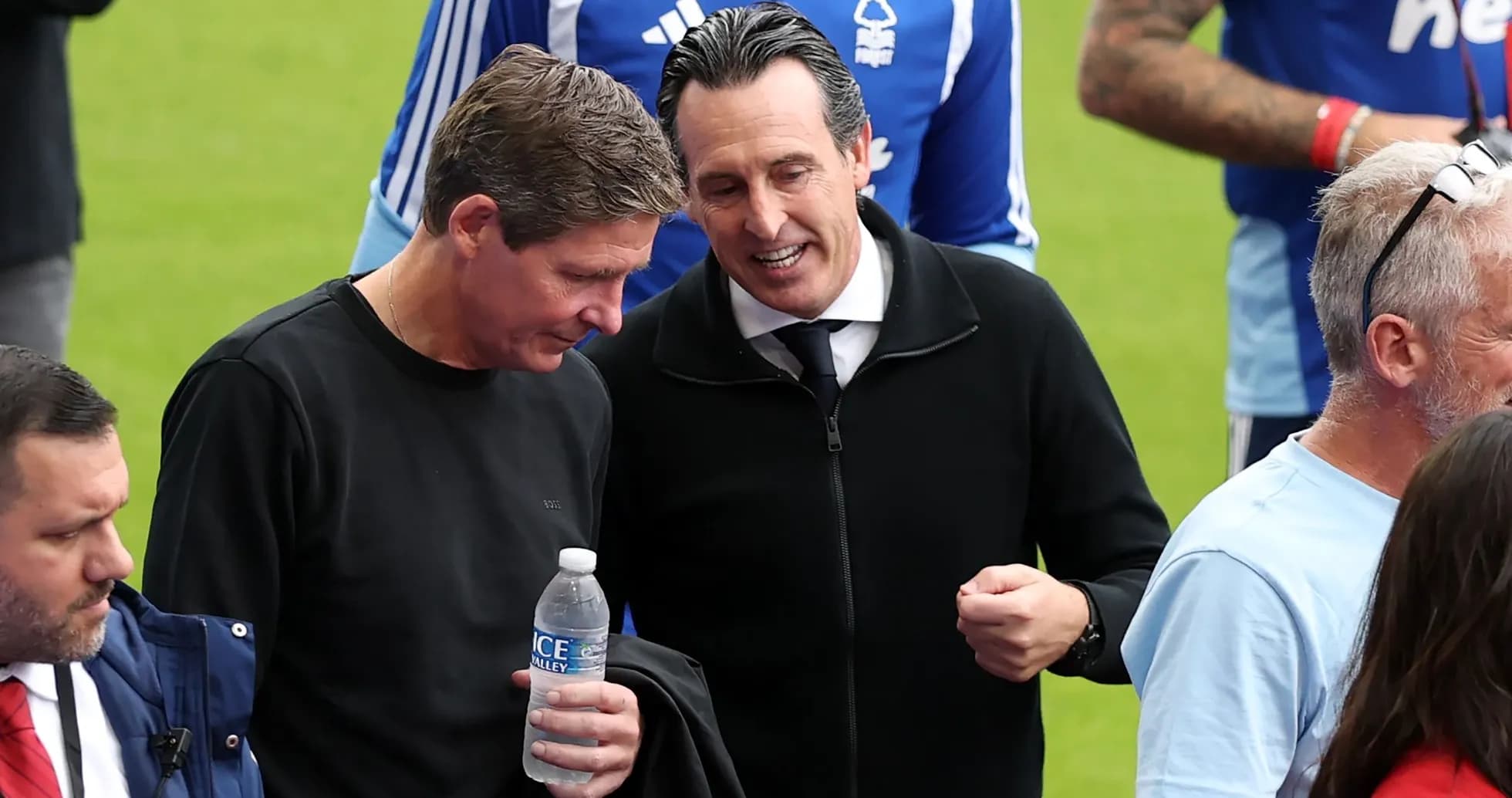 Two men conversing on the pitch before match Two men conversing on the pitch before match