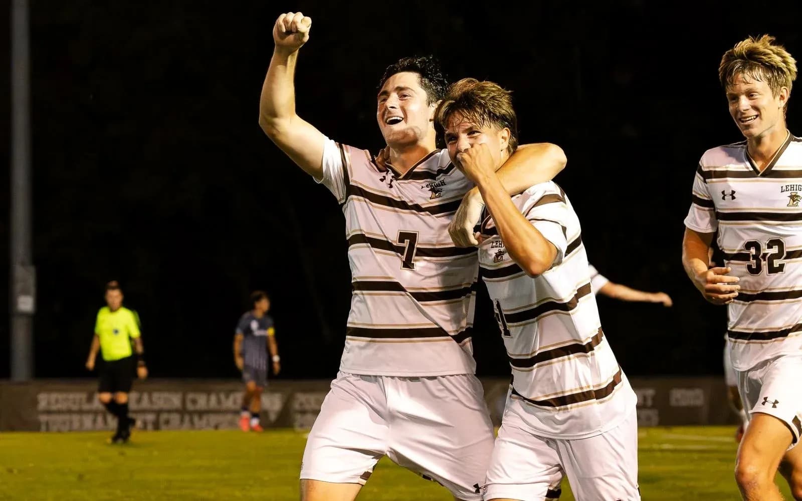Players celebrating a goal on the soccer field Players celebrating a goal on the soccer field
