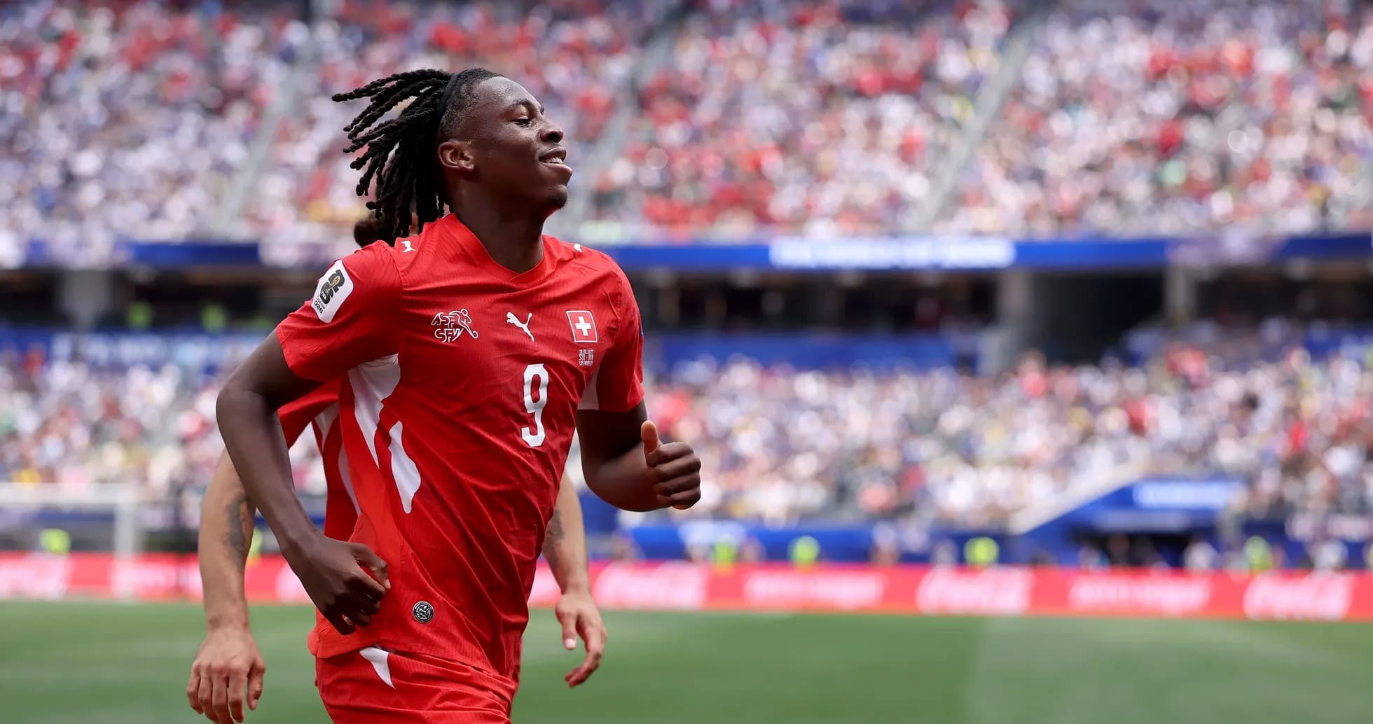 Player celebrating during a match in red uniform Player celebrating during a match in red uniform