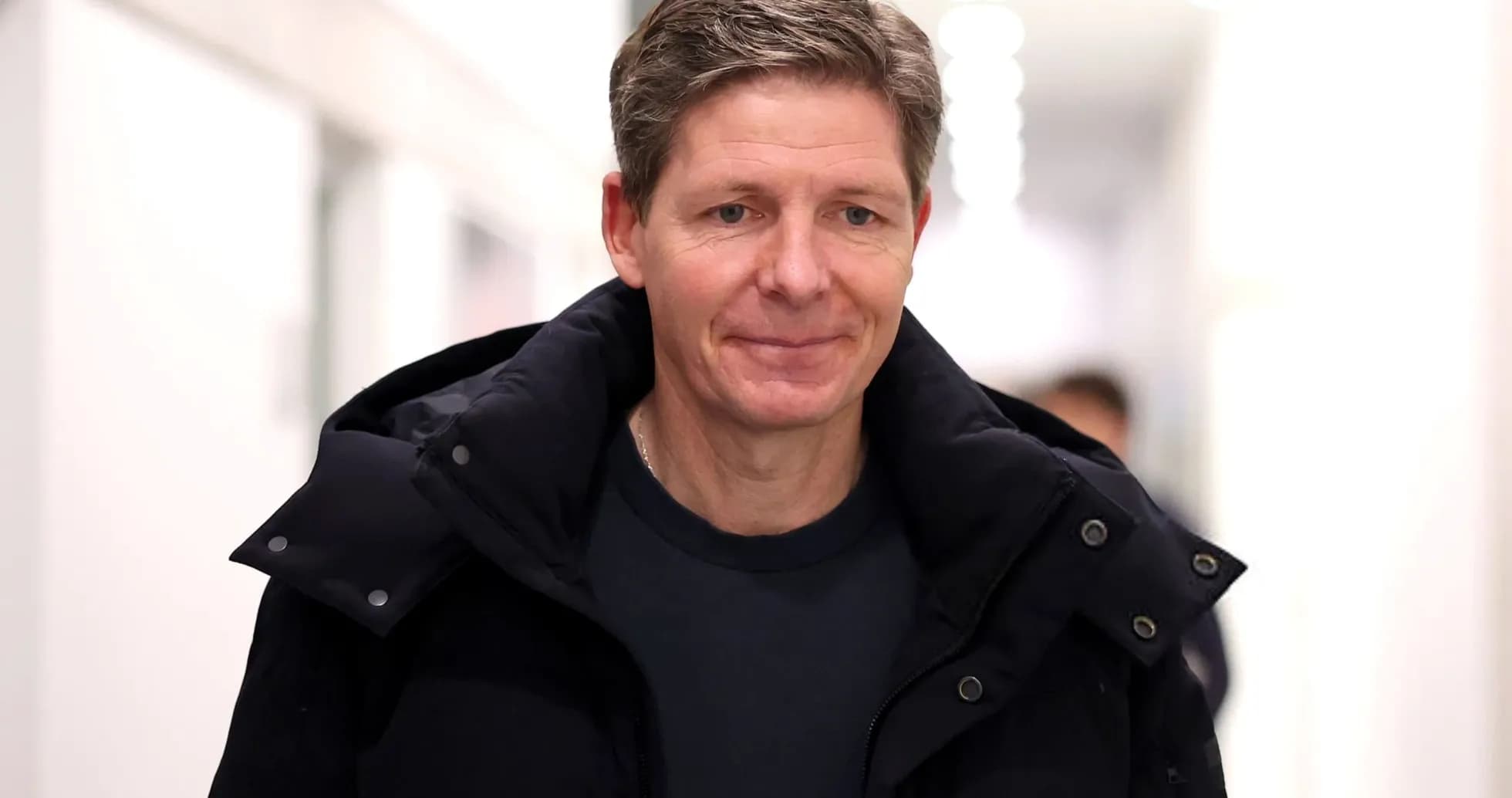 Man walking in a hallway wearing a black jacket Man walking in a hallway wearing a black jacket