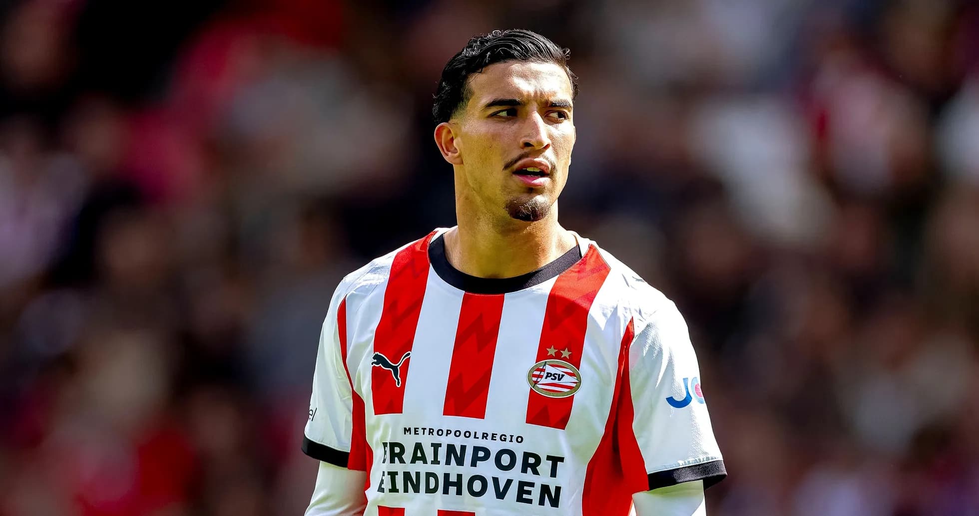 Player wearing PSV Eindhoven jersey on the field Player wearing PSV Eindhoven jersey on the field