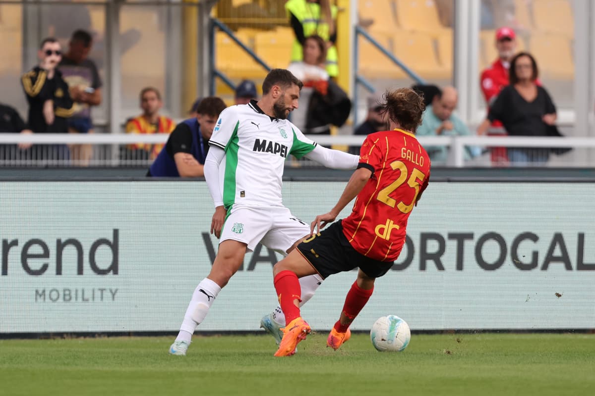Sassuolo player tackling Lecce player during match Sassuolo player tackling Lecce player during match