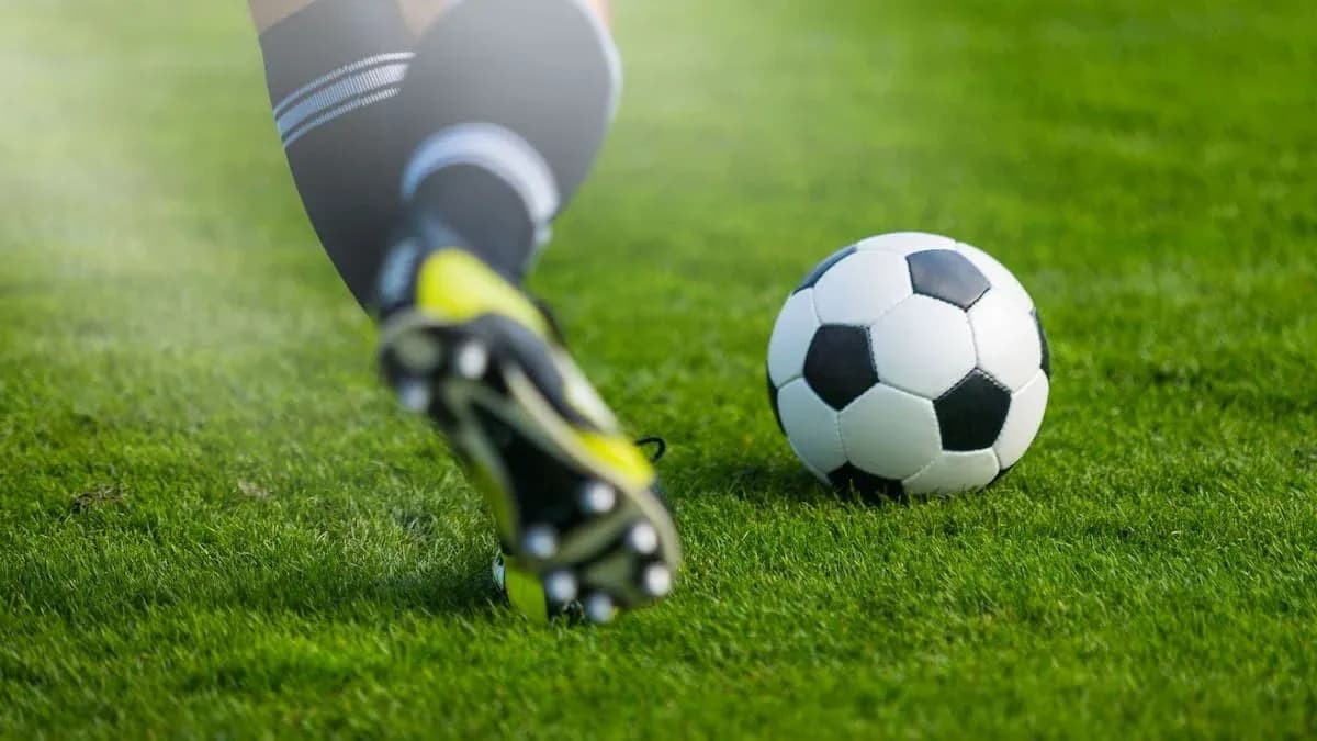 Player kicking a soccer ball on grass field Player kicking a soccer ball on grass field