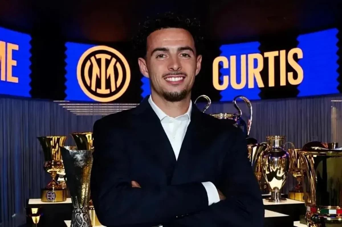 Person smiling in front of trophies and banners Person smiling in front of trophies and banners