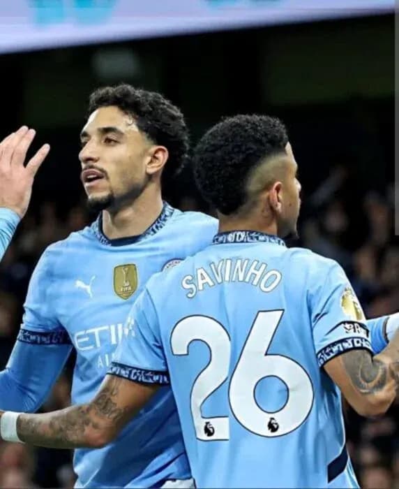 Two Manchester City players celebrating on the pitch Two Manchester City players celebrating on the pitch