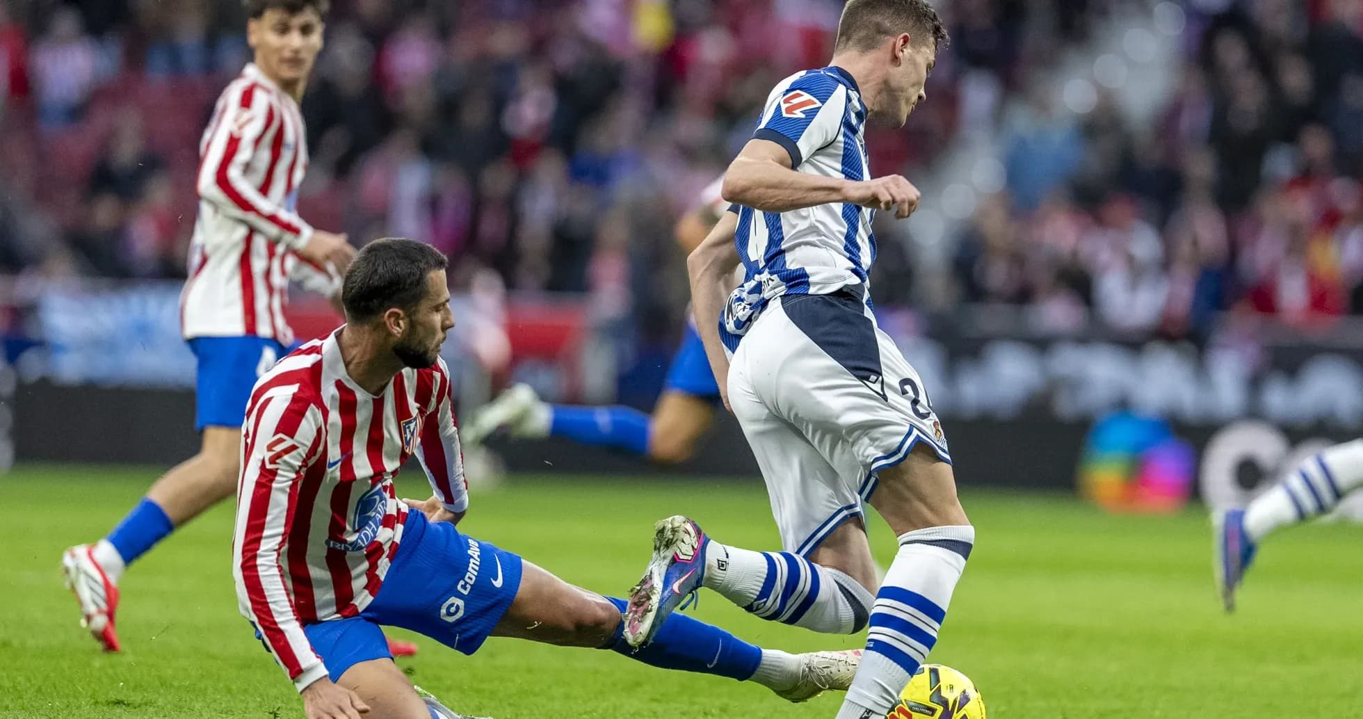 Real Sociedad player tackles Atletico Madrid opponent Real Sociedad player tackles Atletico Madrid opponent