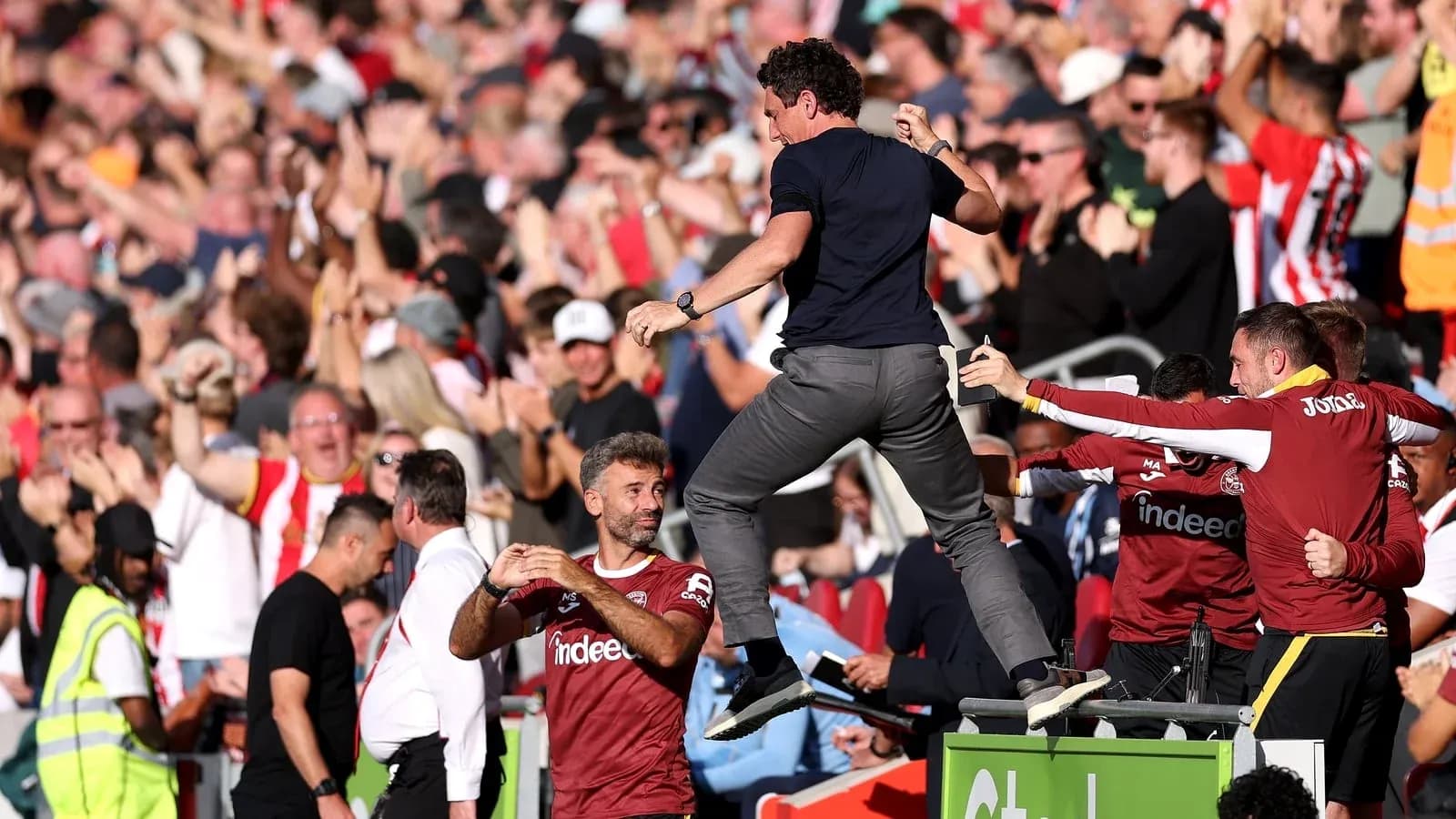 Coach celebrating with fans after a goal Coach celebrating with fans after a goal