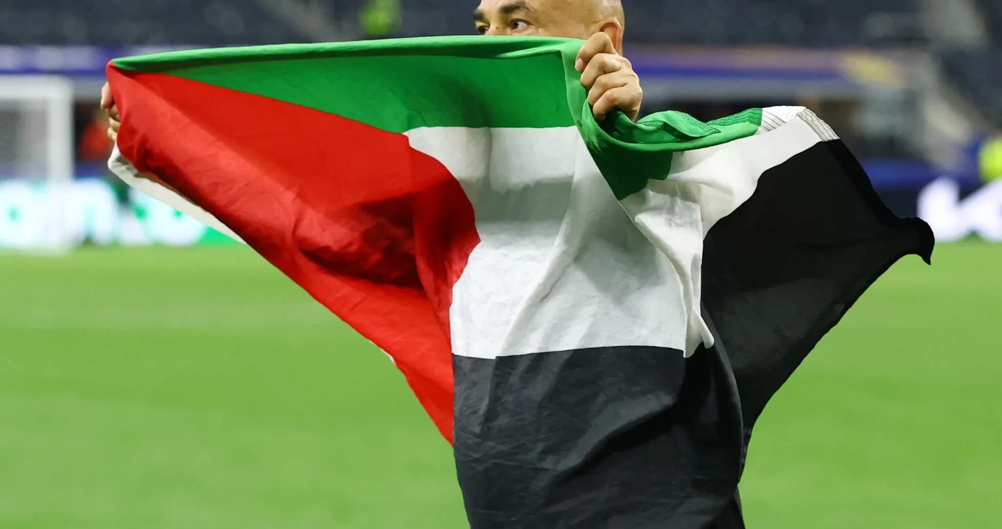 Person holding a flag celebrating on the field Person holding a flag celebrating on the field