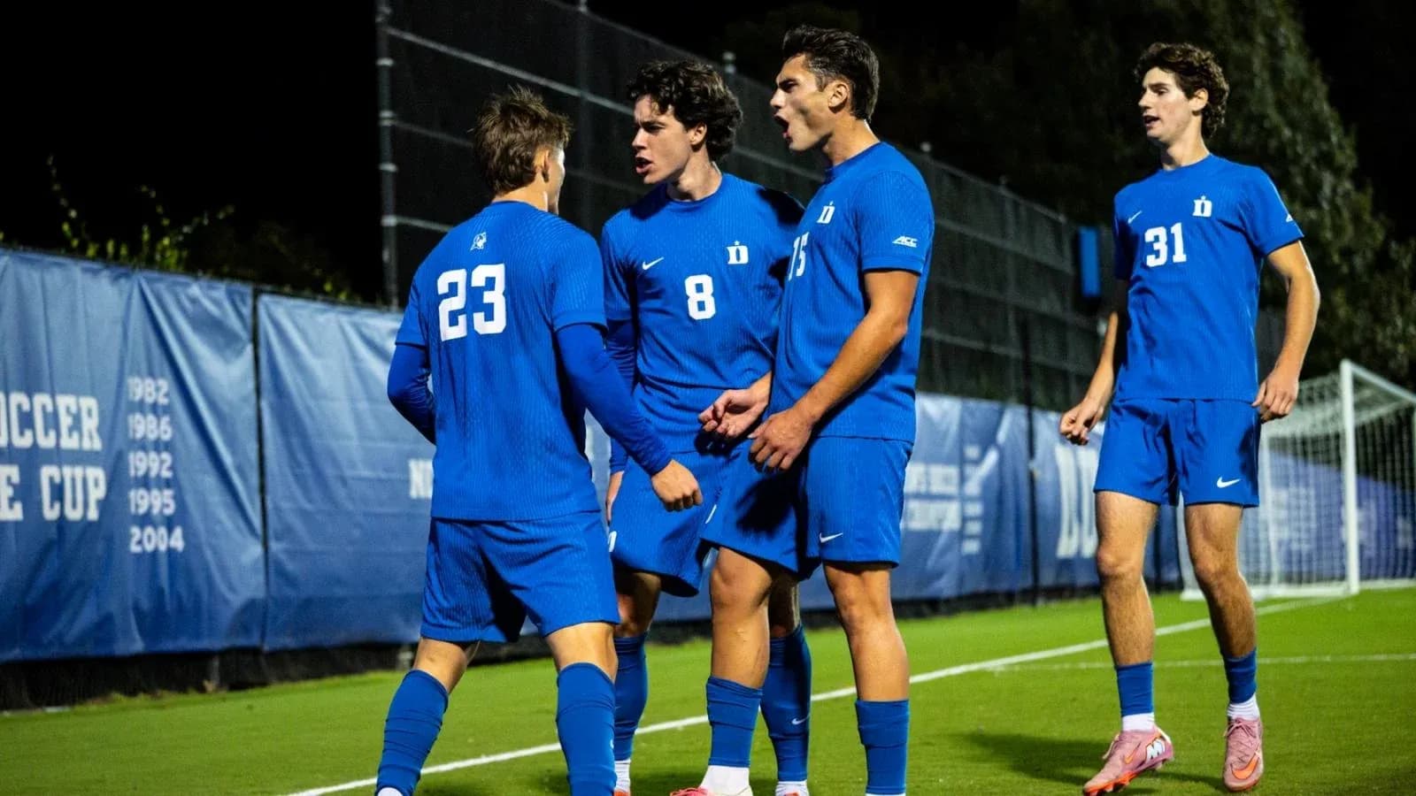 Duke players celebrating a goal on the field Duke players celebrating a goal on the field