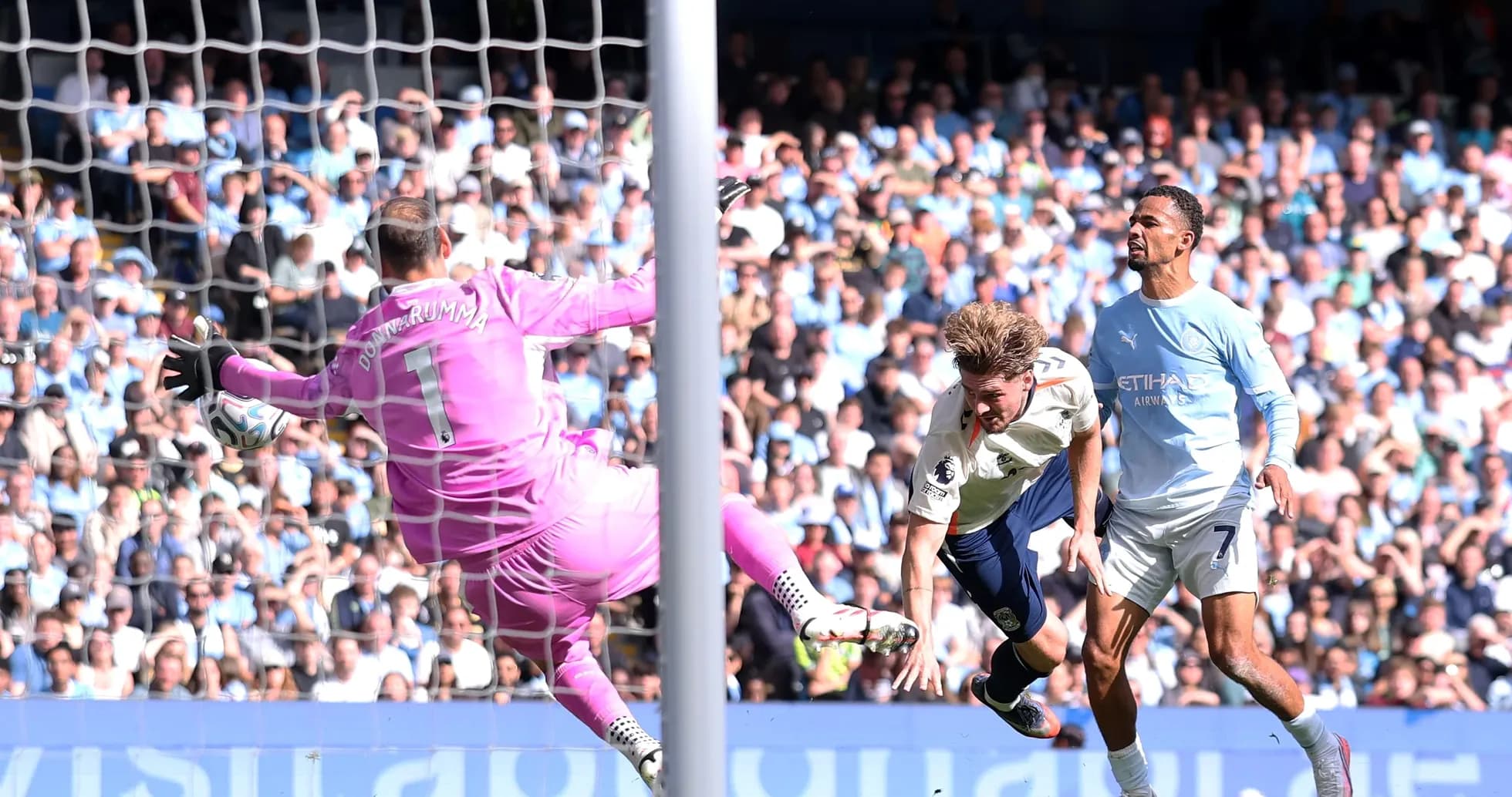 Player attempting to score as goalkeeper dives Player attempting to score as goalkeeper dives