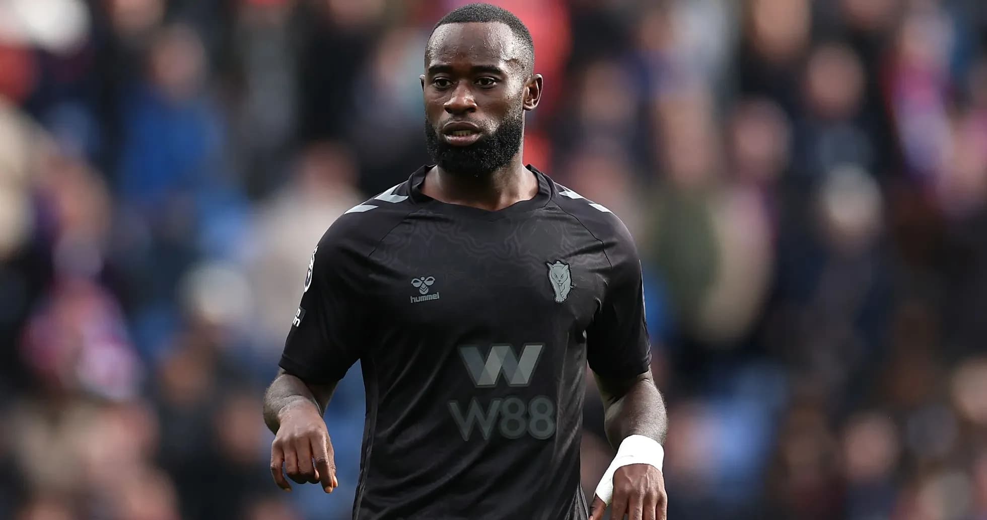 Player in black kit during a football match Player in black kit during a football match