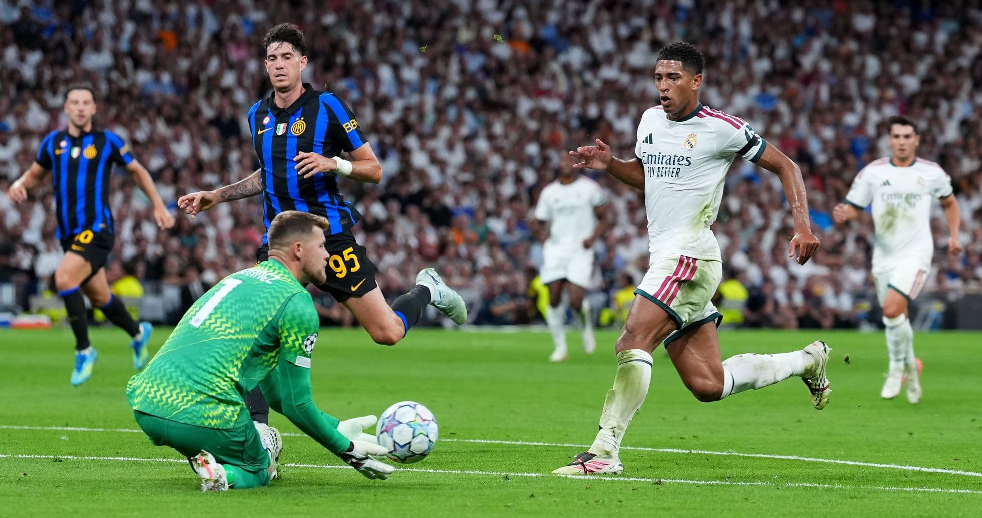 Real Madrid player chasing the ball past goalkeeper Real Madrid player chasing the ball past goalkeeper