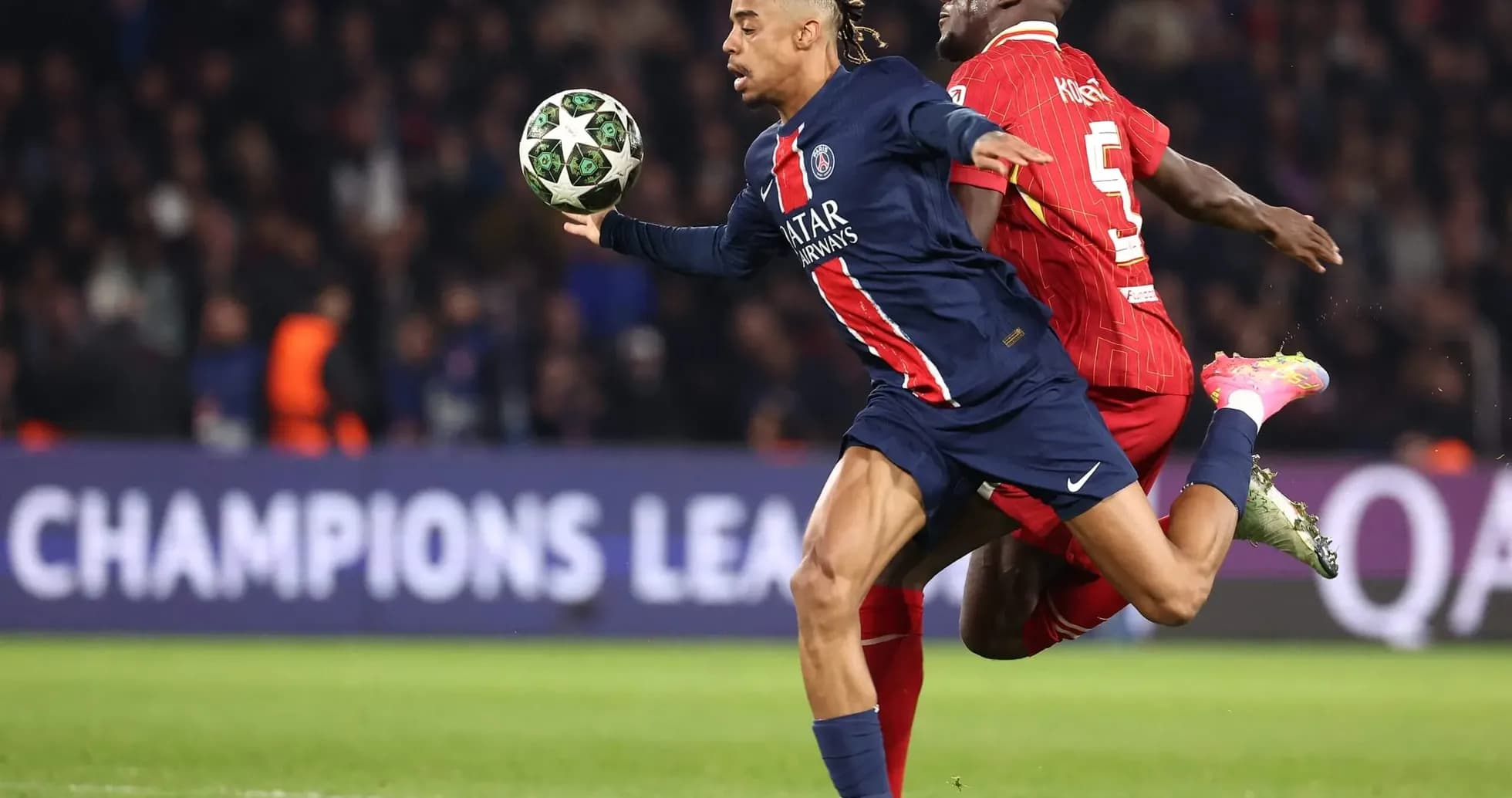 PSG player in action against Liverpool defender PSG player in action against Liverpool defender