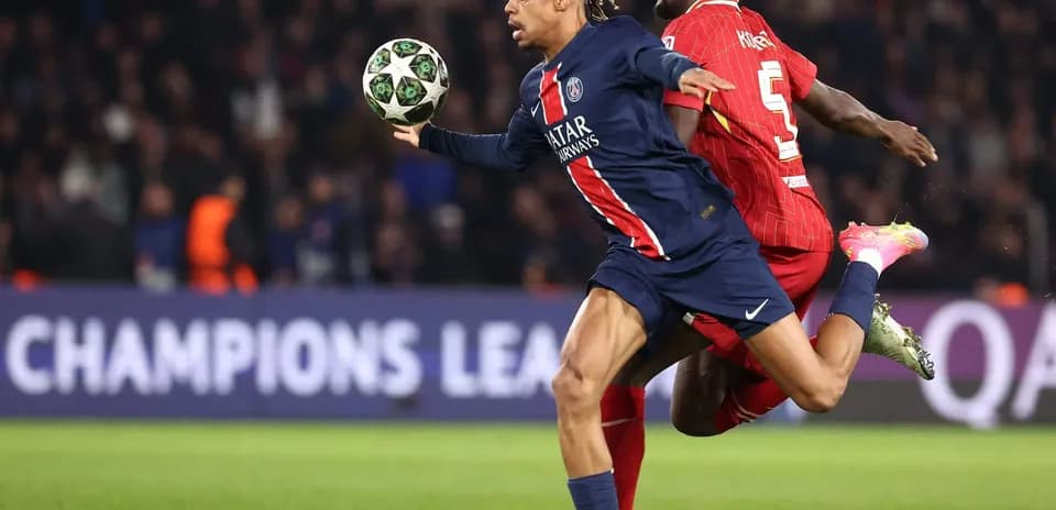 PSG player in action against Liverpool defender PSG player in action against Liverpool defender