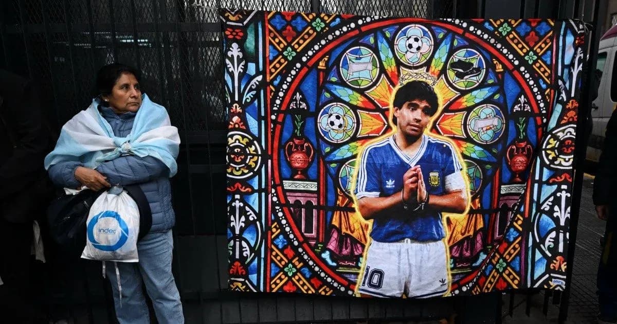 Woman with Argentine flag near mural of Maradona Woman with Argentine flag near mural of Maradona
