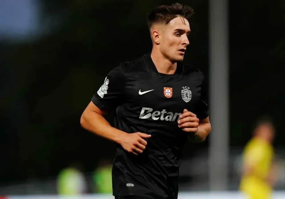 Player running during a football match wearing black kit Player running during a football match wearing black kit