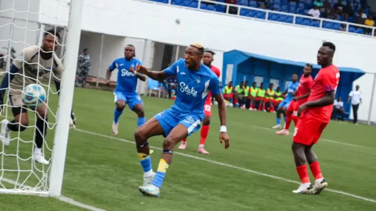 Player kicking ball near goal in NPFL match Player kicking ball near goal in NPFL match
