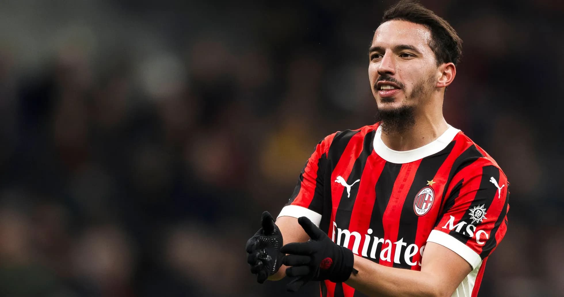 Player in AC Milan jersey gesturing on the field Player in AC Milan jersey gesturing on the field