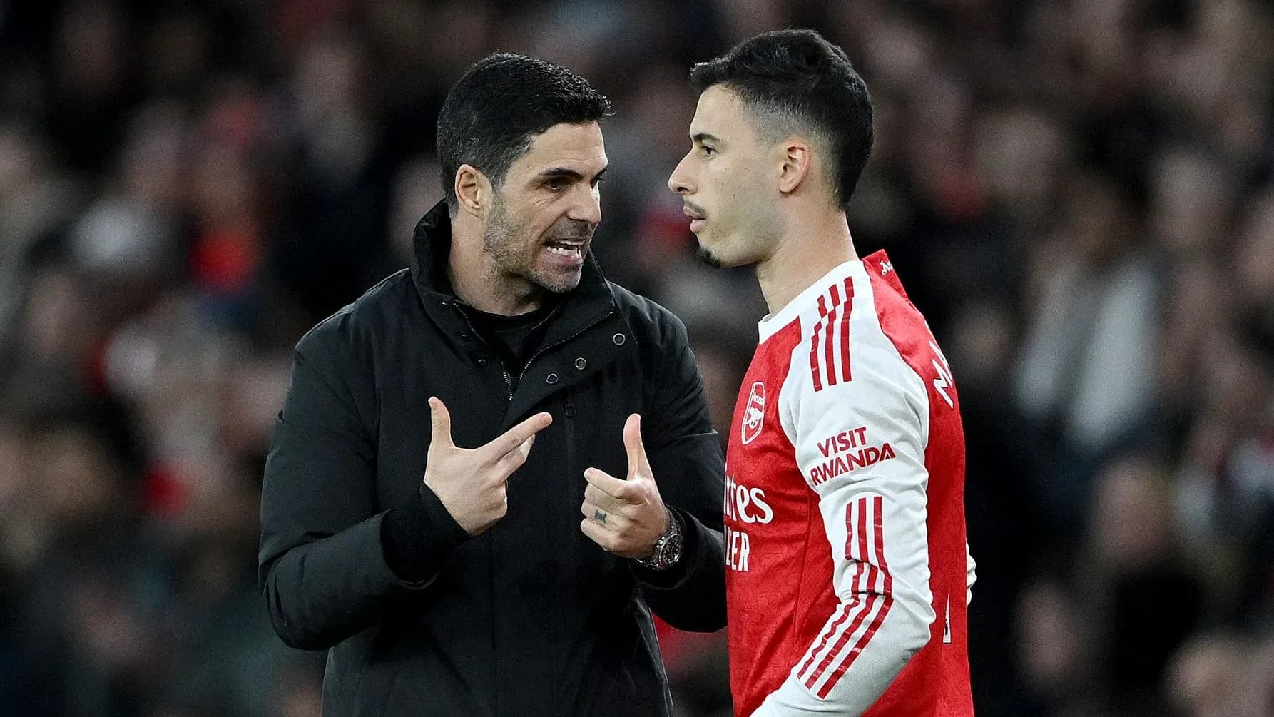 Manager discussing strategy with player on sideline Manager discussing strategy with player on sideline