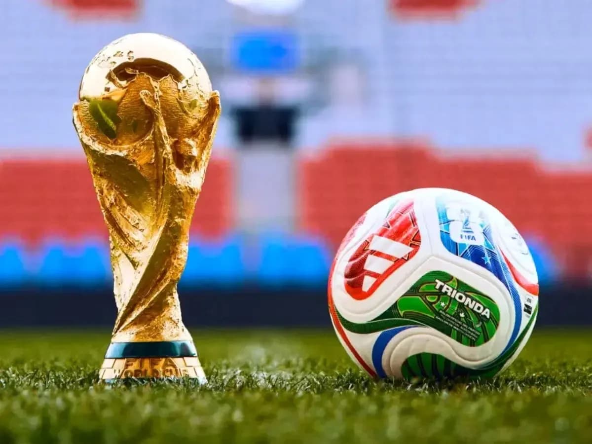 FIFA World Cup trophy and soccer ball on grass FIFA World Cup trophy and soccer ball on grass