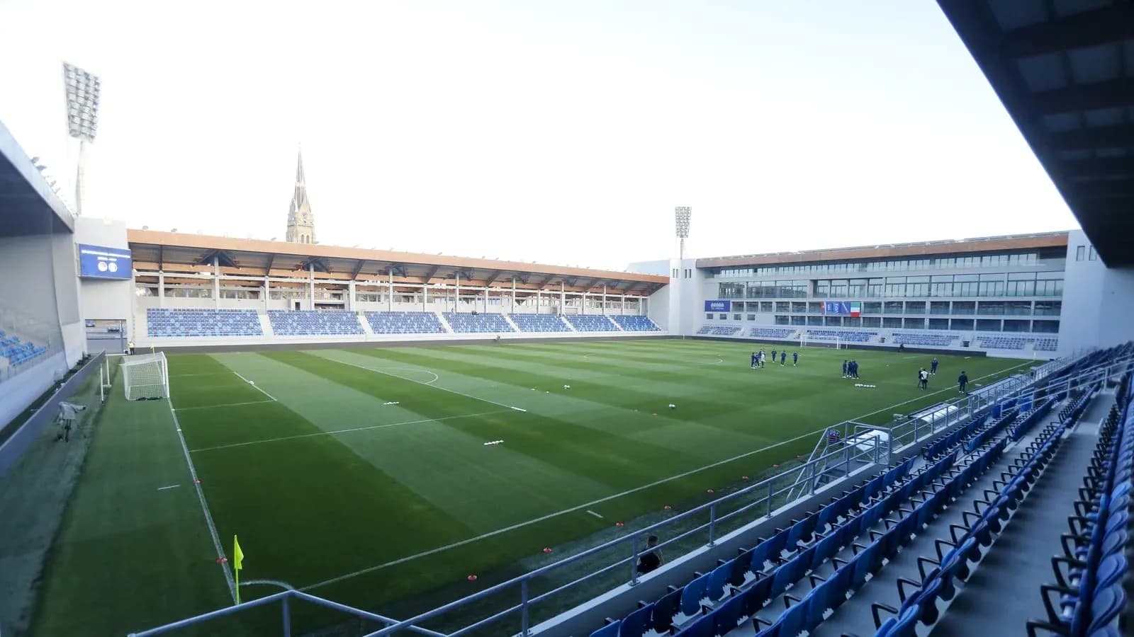 Football stadium with players training on the pitch Football stadium with players training on the pitch