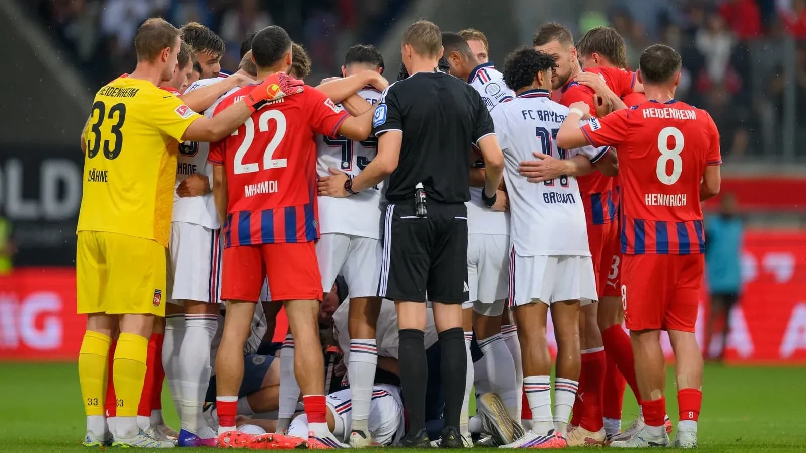 Players from both teams huddled during stoppage Players from both teams huddled during stoppage