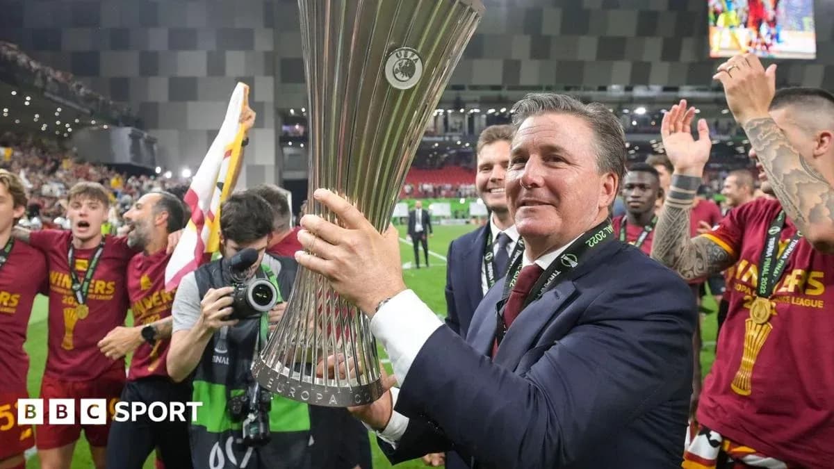 Manager celebrating with UEFA trophy and team members Manager celebrating with UEFA trophy and team members