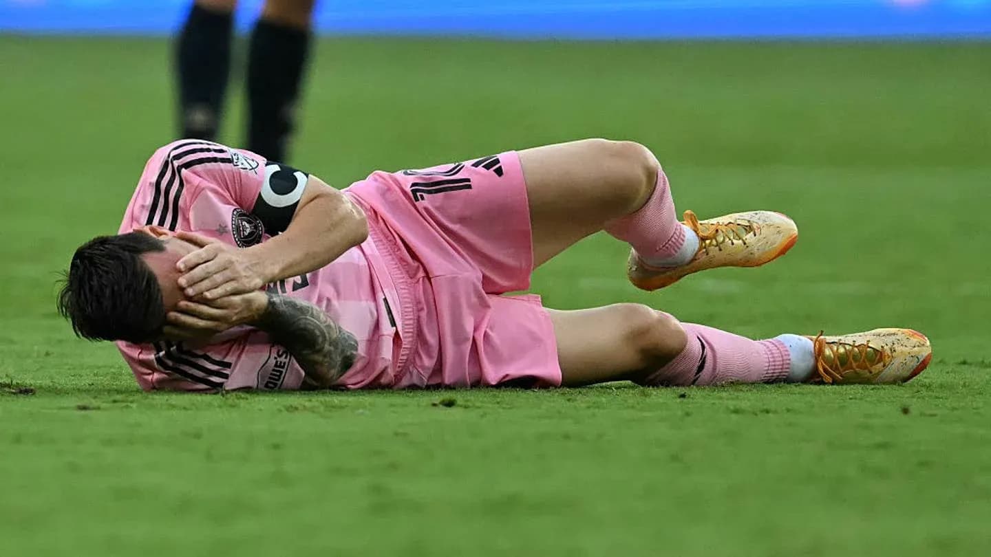 Player lying on ground, holding face in pain Player lying on ground, holding face in pain