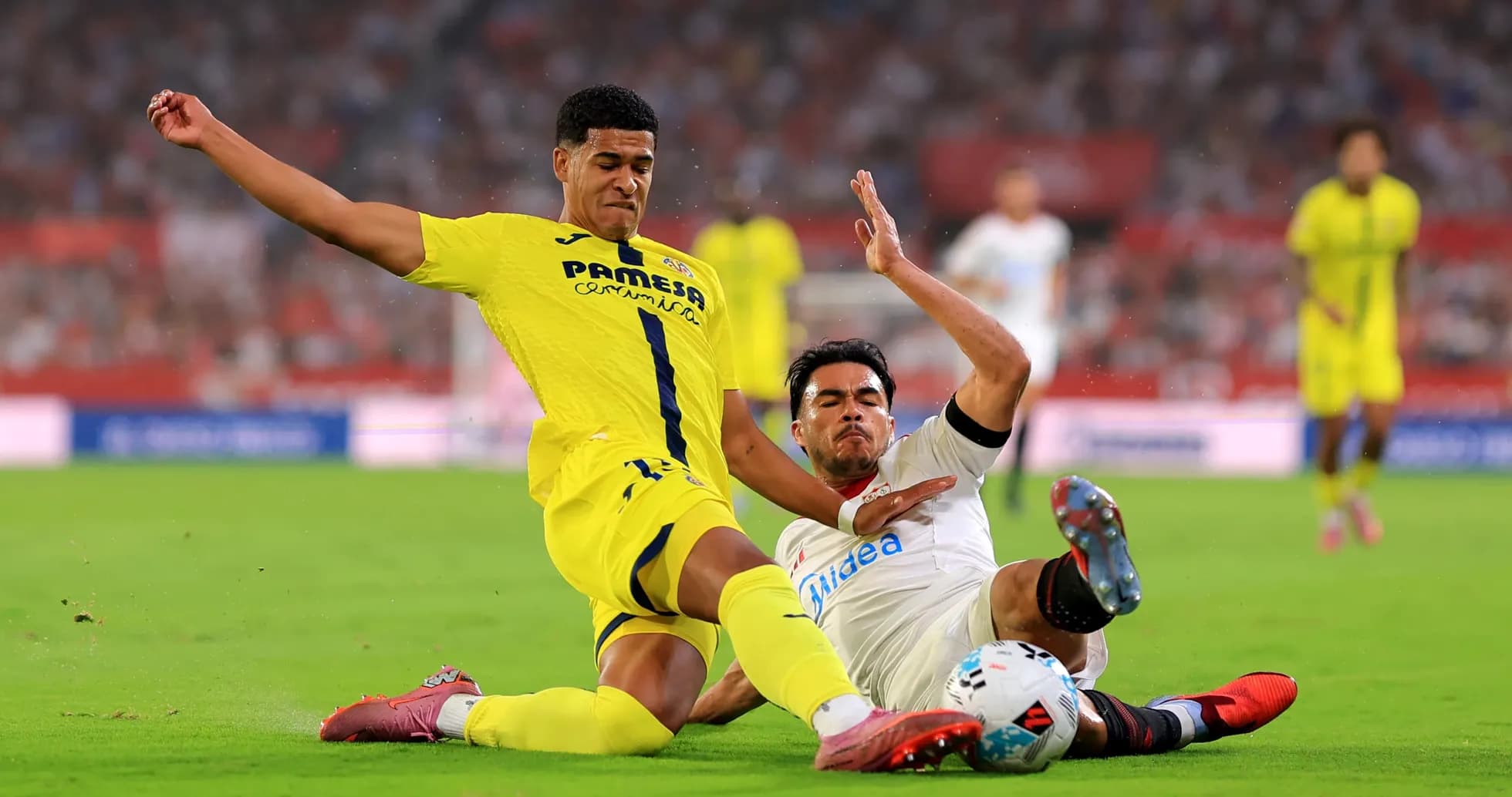 Villarreal player tackling Sevilla opponent during match Villarreal player tackling Sevilla opponent during match