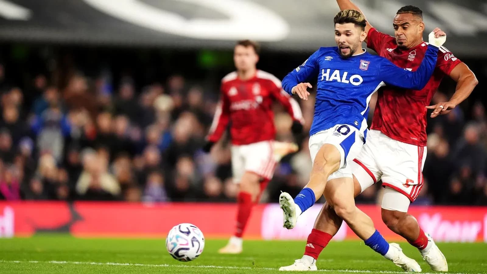 Player in blue tackling opponent in red during match Player in blue tackling opponent in red during match