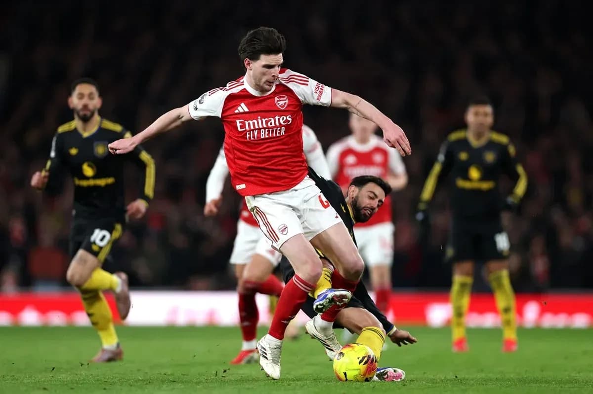 Arsenal player challenged by opponent during match Arsenal player challenged by opponent during match