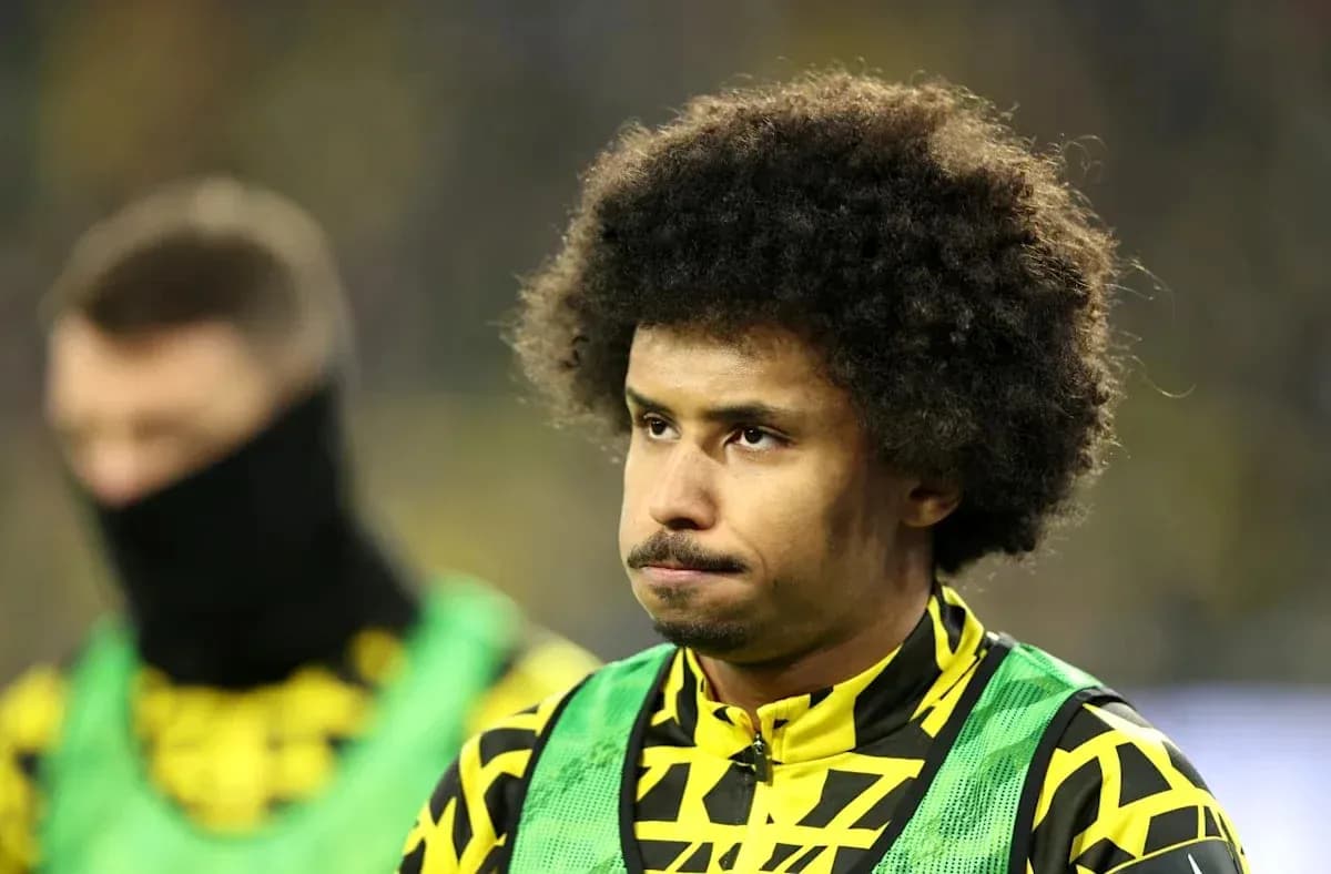 Player in yellow and black kit on sidelines Player in yellow and black kit on sidelines