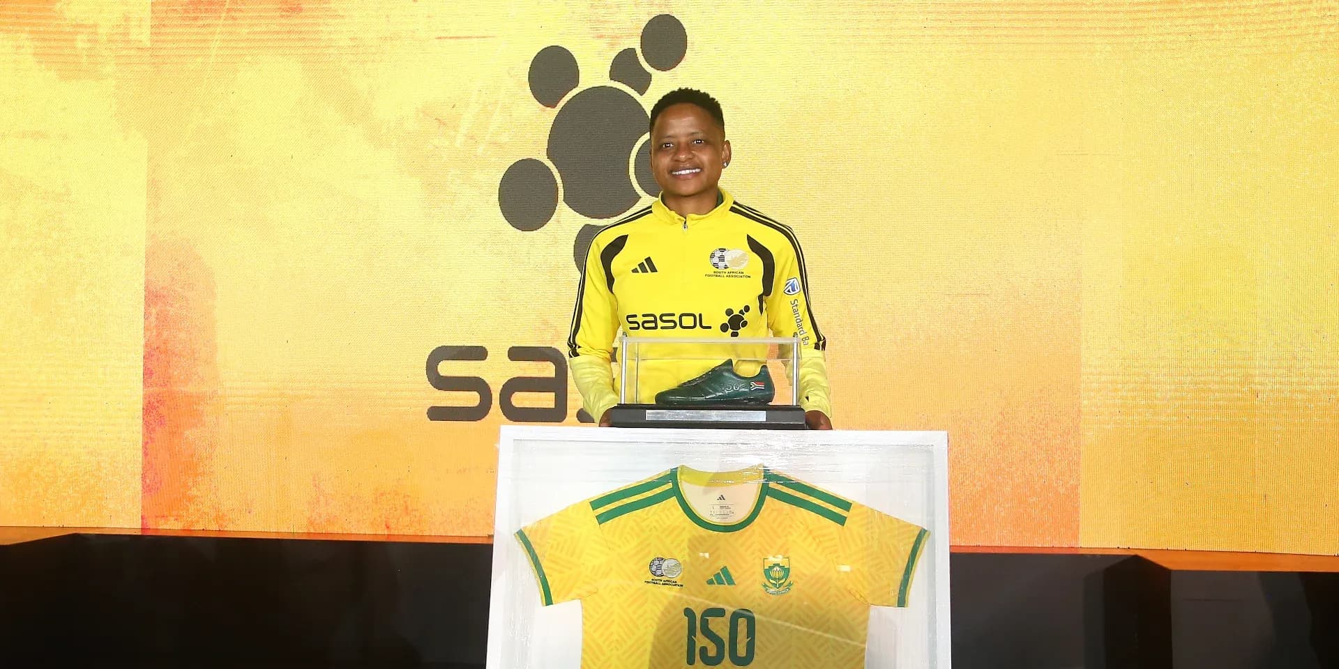 Player holding a trophy and jersey at event Player holding a trophy and jersey at event
