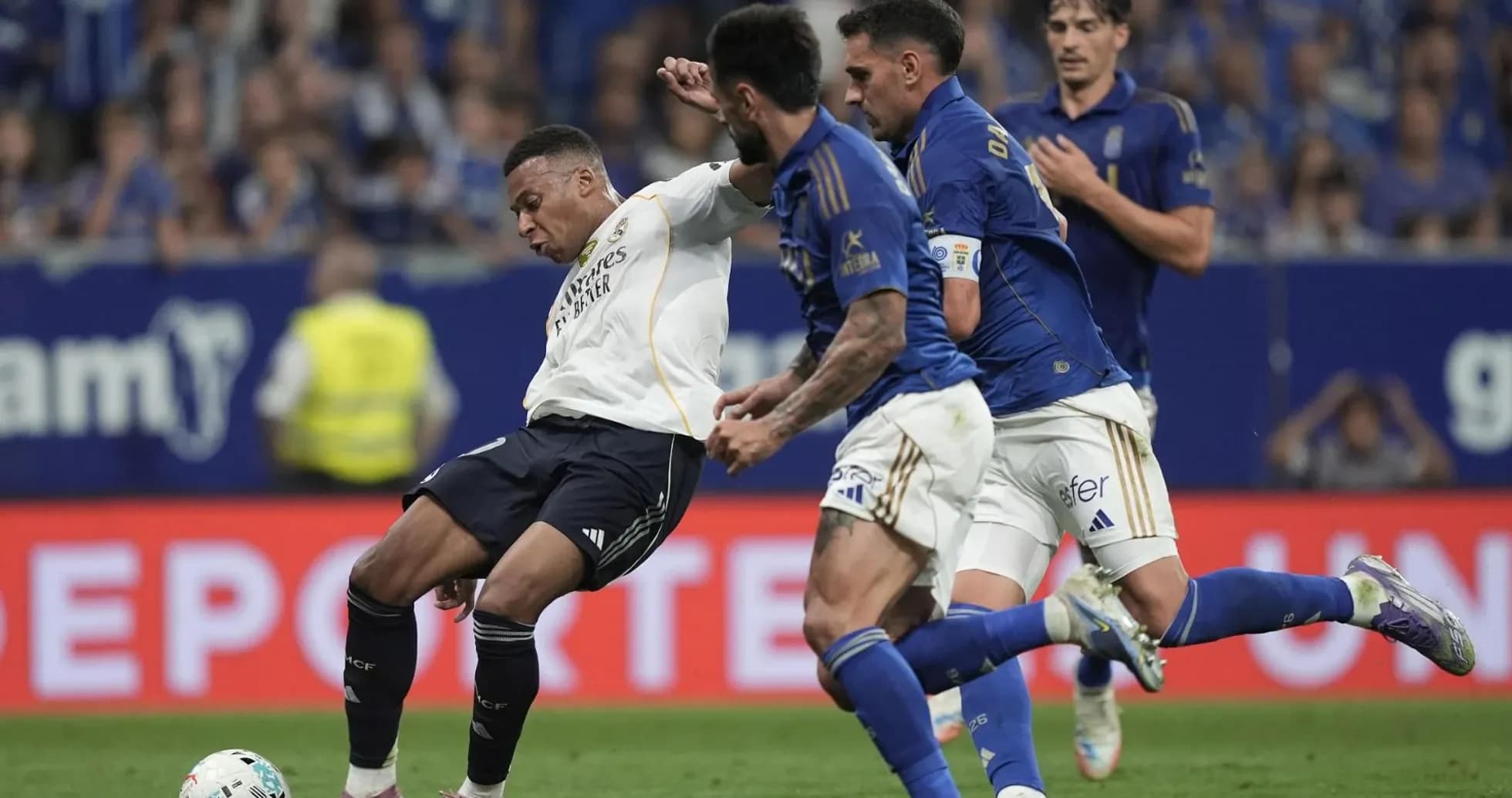 Real Madrid player challenged by Oviedo defenders Real Madrid player challenged by Oviedo defenders