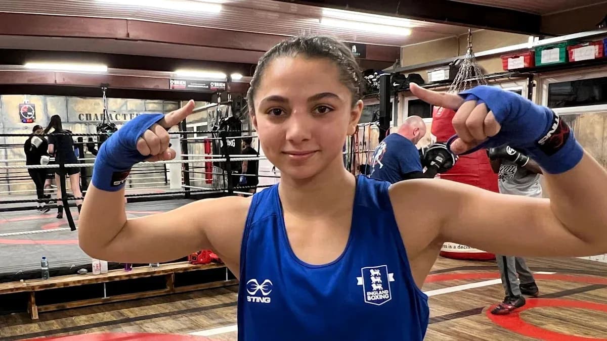 Female boxer posing in training gym with gloves Female boxer posing in training gym with gloves
