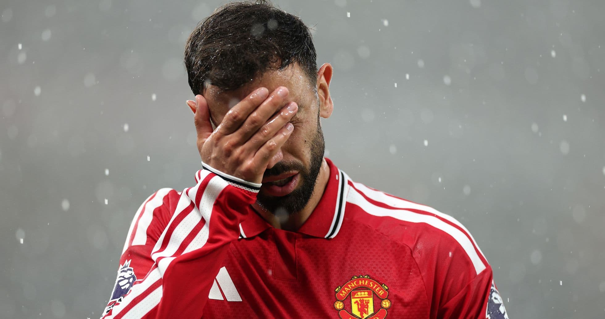 Player in red jersey covering face in rain Player in red jersey covering face in rain