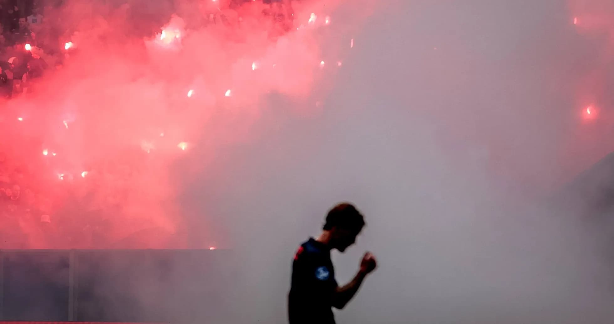 Player celebrating in front of smoke and flares Player celebrating in front of smoke and flares