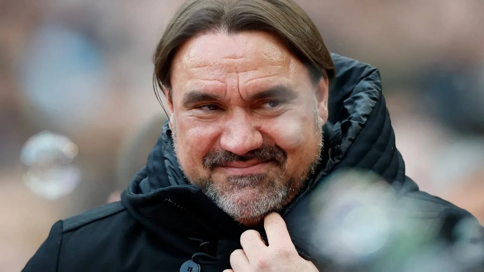 Man in black jacket smiling during event Man in black jacket smiling during event