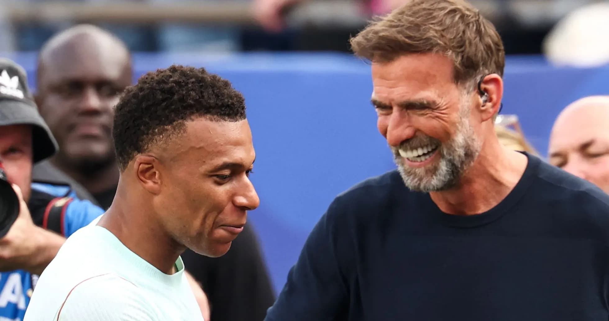 Kylian Mbappé and manager smiling during interaction Kylian Mbappé and manager smiling during interaction