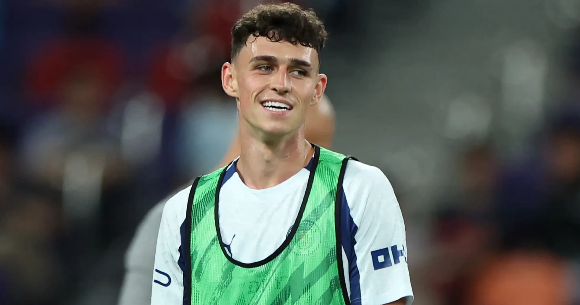 Player wearing training bib smiling on the pitch Player wearing training bib smiling on the pitch