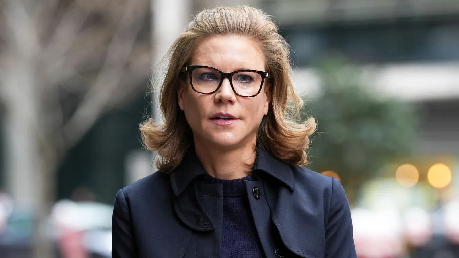 Woman in glasses walking outside with blurred background Woman in glasses walking outside with blurred background