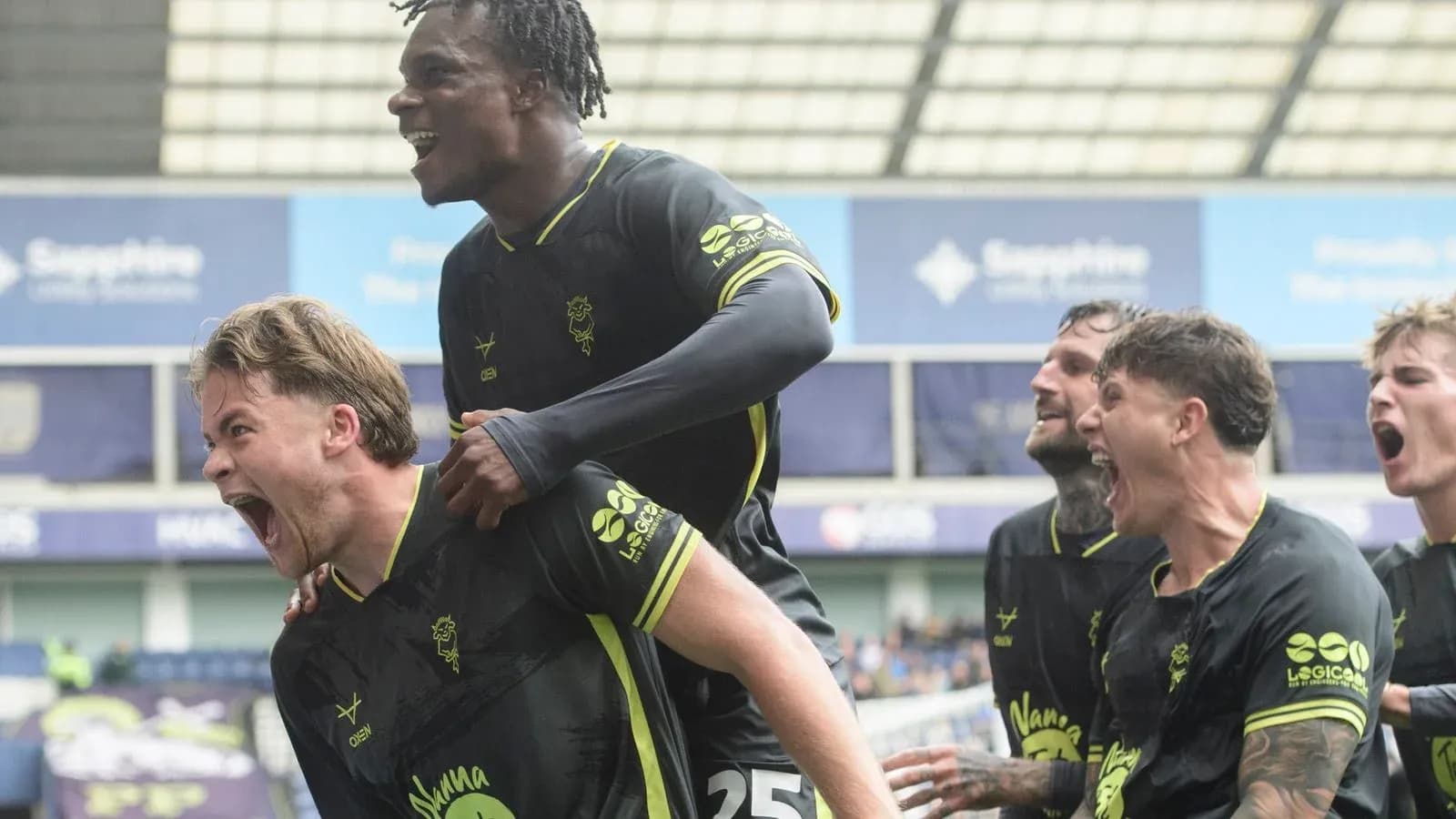 Players celebrating a goal with excitement on field Players celebrating a goal with excitement on field
