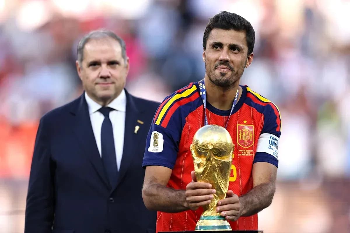 Player holding World Cup trophy with official nearby Player holding World Cup trophy with official nearby