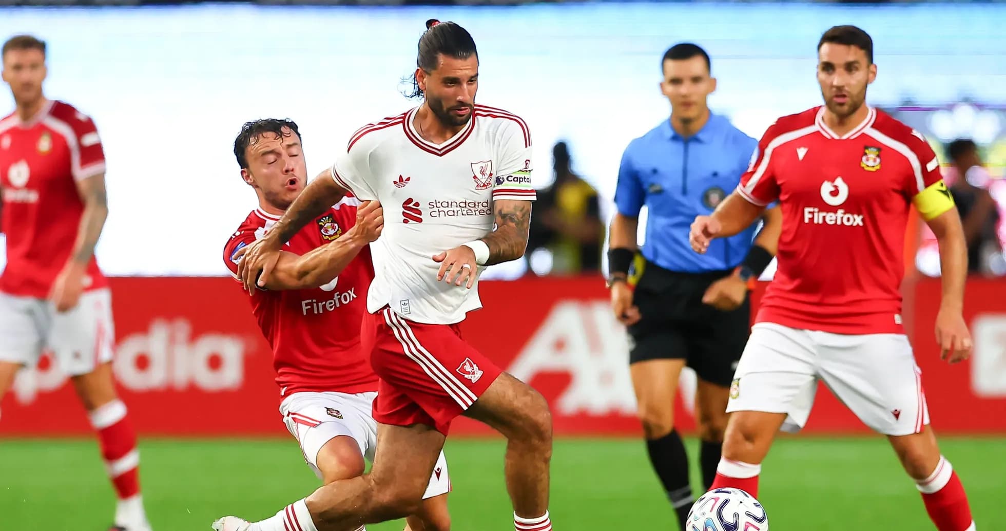 Player in white jersey dribbling past opponent in red Player in white jersey dribbling past opponent in red