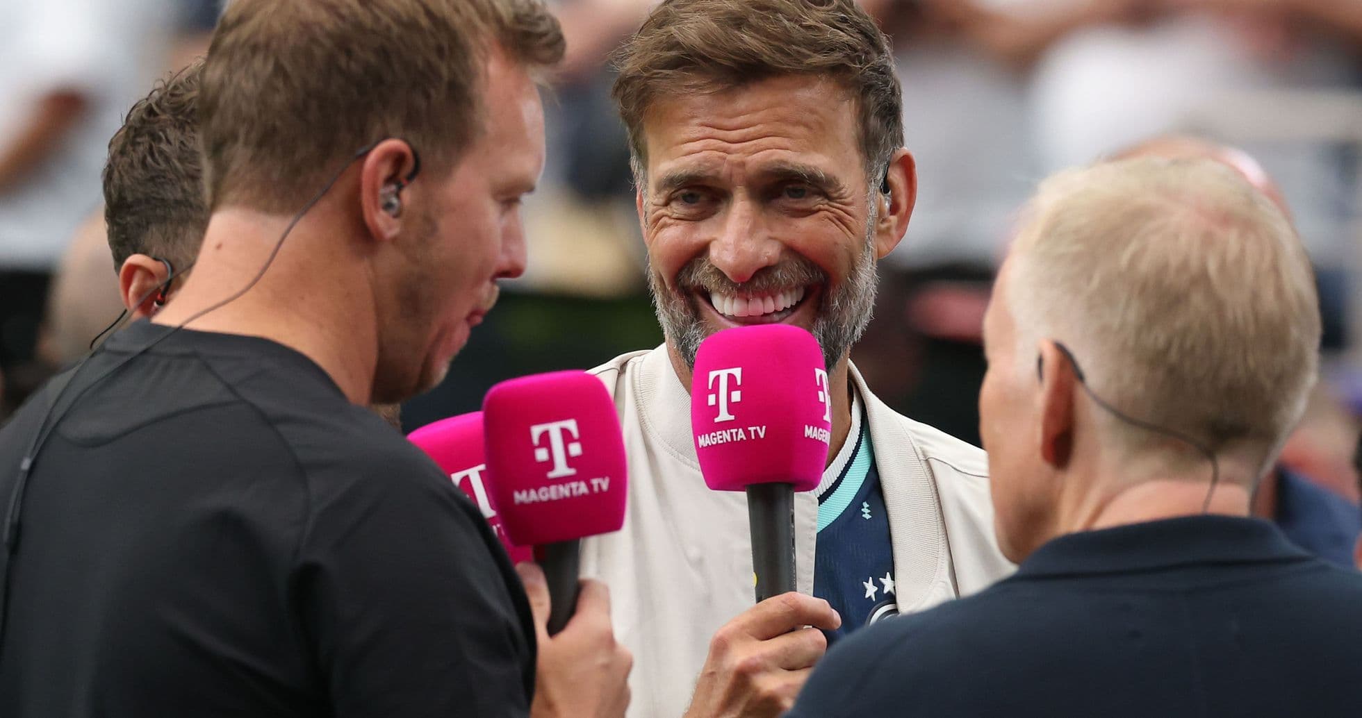 Three men holding microphones during an interview Three men holding microphones during an interview