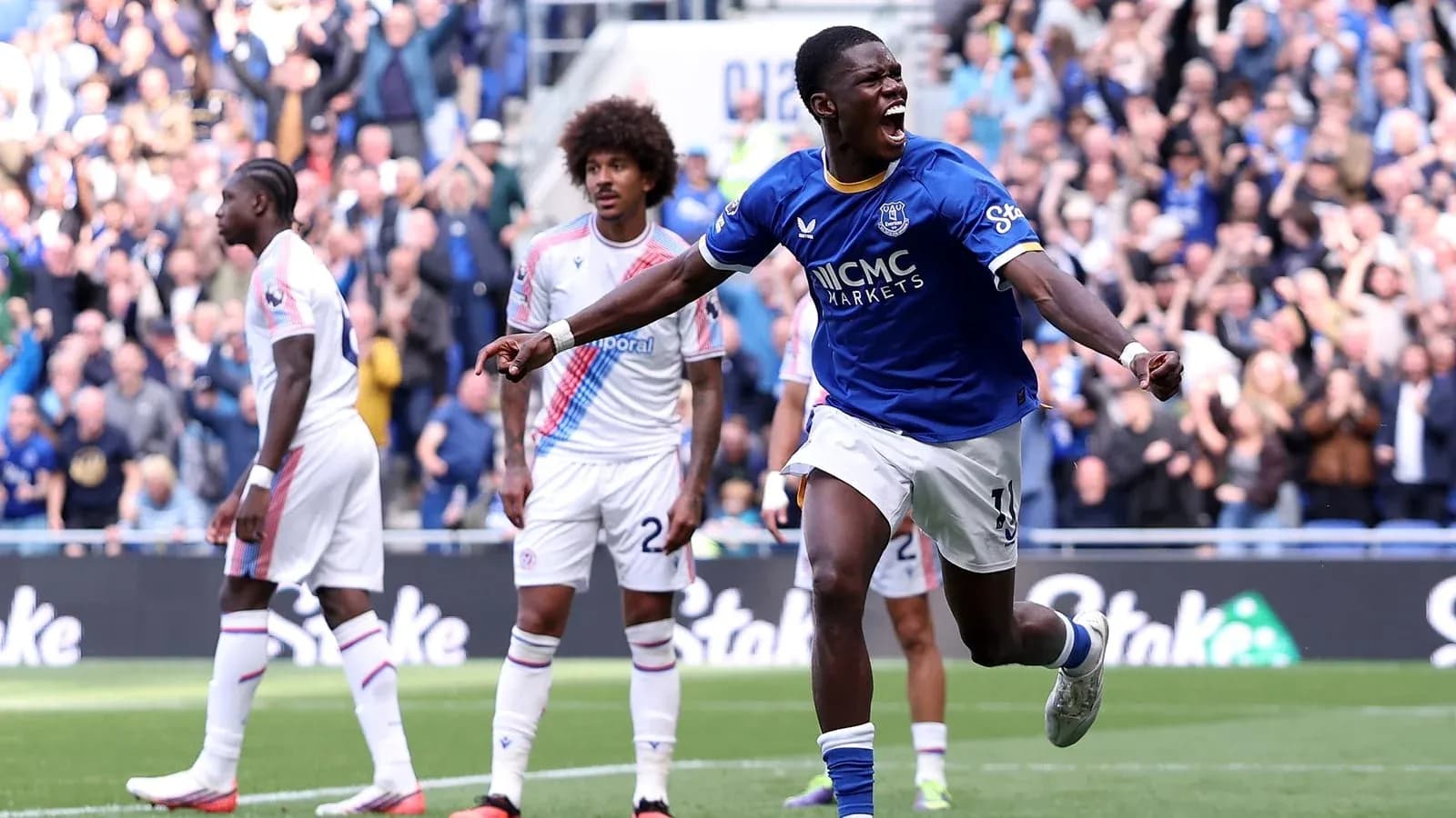 Player celebrating goal with teammates in stadium Player celebrating goal with teammates in stadium